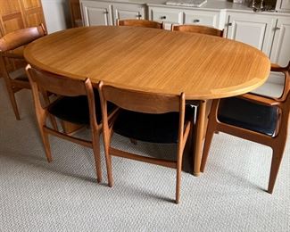 Danish Mid Century Modern Dining Room Table and Chairs. A truly lovely set in very good condition with light wear. As seen, the table measures 70.5" x 45" x 29.5" with two additional leaves stored under the table. 

Comes with six chairs featuring a lovely curved design and includes two host chairs. Looks to be by Skovby, however; no maker's mark was found. 