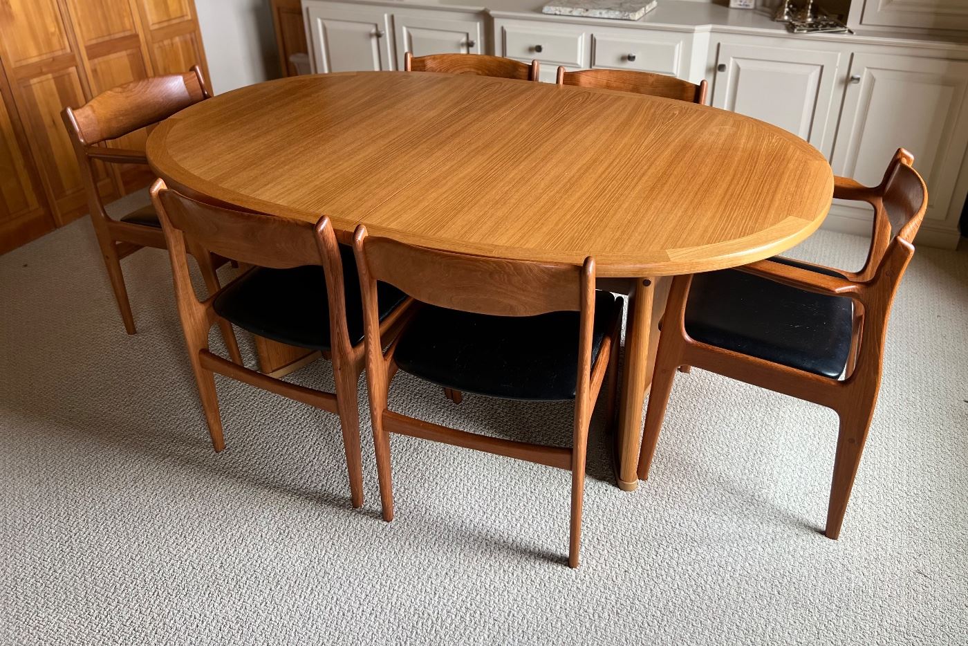 Danish Mid Century Modern Dining Room Table and Chairs. A truly lovely set in very good condition with light wear. As seen, the table measures 70.5" x 45" x 29.5" with two additional leaves stored under the table. 

Comes with six chairs featuring a lovely curved design and includes two host chairs. Looks to be by Skovby, however; no maker's mark was found. 