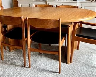 Danish Mid Century Modern Dining Room Table and Chairs. A truly lovely set in very good condition with light wear. As seen, the table measures 70.5" x 45" x 29.5" with two additional leaves stored under the table. 

Comes with six chairs featuring a lovely curved design and includes two host chairs. Looks to be by Skovby, however; no maker's mark was found. 