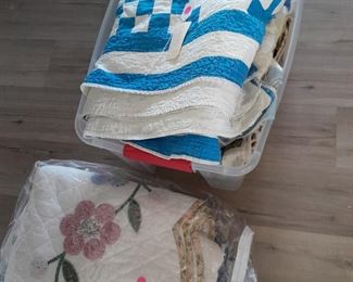 A tote with several vintage quilts in excellent shape