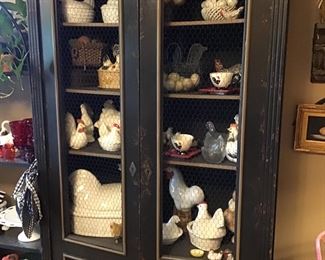 Black cabinet with chicken wire. Large rooster collection