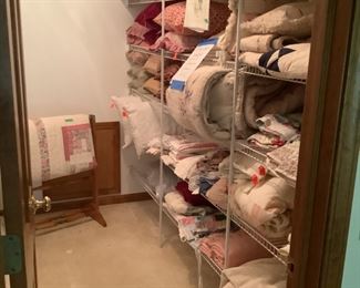 Closet full of linens and pillows and quilts.  Also quilt rack.