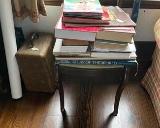 More books than we can shelve. To the left are a handful of nautical maps.