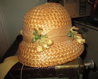 Vintage straw hat atop a vintage steamer trunk