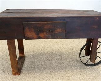 1103	PRIMITIVE WOOD INDUSTRIAL/FLORIST STYLE CART W/ONE DRAWER & METAL WHEEL, APPROXIMATELY 55 IN X 19 IN X 30 IN HIGH

