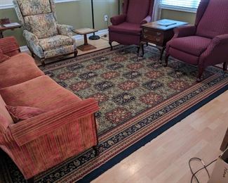 Antique sofa,  upholstered wingback chairs and a gorgeous area rug 