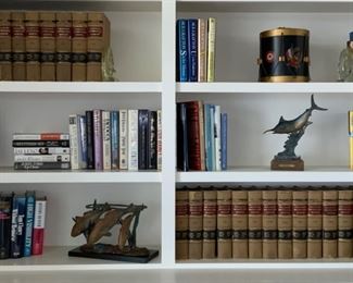 Build in Book Shelf Showcasing collection of BL Palmer, national reporter, system, southwestern reporter, law books.  French military style drum ice bucket, sounding blue marlin sculpture by Kent Ullberg, solid brass 3- fish sculpture 