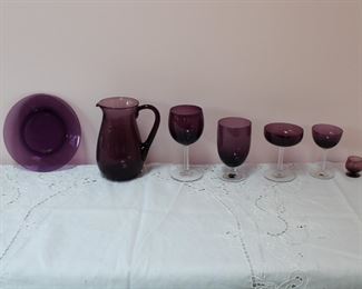 Classic Amethyst by Fostoria Glass Company, showing an example of each size stemware that is available, along with luncheon size plates