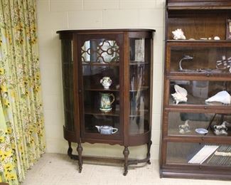 Antique oak curved glass china cabinet with fretwork trim on door