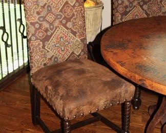 Highbacked chairs with distressed leather seats.