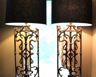 A pair of very tall matching lamps with ornate iron scrolling.  
