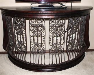 This large, half moon shaped console, sofa table features a unique blend of iron and wood to produce a dramatic effect for almost any room.