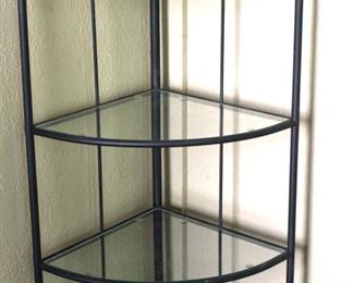 Iron corner rack with glass shelves.