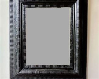 $800 An ebonised carved mirror late 19th C.