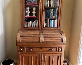 Absolutely stunning turn of the century secretary with a barrel style fold down leather top desk, crock, books, busts, pottery