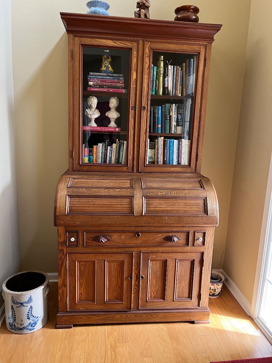 Absolutely stunning turn of the century secretary with a barrel style fold down leather top desk, crock, books, busts, pottery