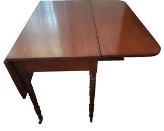 Walnut 1800s Sheraton style drop leaf table with barley twist legs and original casters
