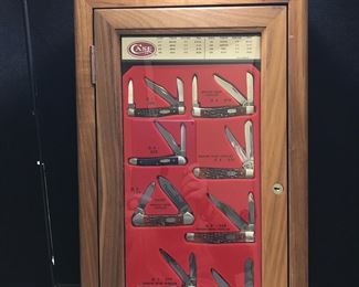 Lot # : 2 - Knife - Case Store Display with 8 Knives
Several with bone handle Trapper, Canoes and more, has storage compartment behind display front, has key Measures: 23" tall 12 1/2" wide x 8 1/4 depth on bottom 4 1/2 depth on top, Knife has not been
