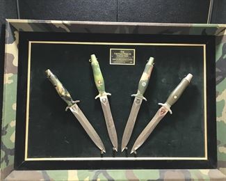 Lot # : 260 - Knife-Gerber Vietnam Tribute Collection # 091/2500
made in 1982 and issued by American Historical Foundation. Consists of 4 Gerber Mark II knives with wasp waist blades. The handles are armorhide aluminum with patterns for each branch of Services - Army, Navy, Air Force, and Marines. Comes with display frame