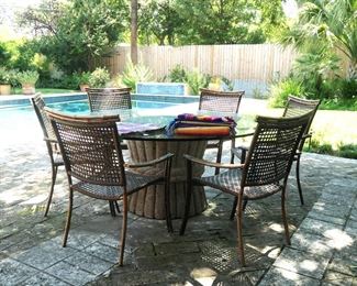 Cement table with glass top and size chairs . Offers welcome on only the chairs or only the table. If the table is sold, the chairs can be sold separately. A few Mexican textiles are seen on the table.