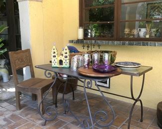 The fifth chair that matches the kitchen set. Two glass and iron side tables, Lucite patio plates and glasses with confetti design. Painted Mexican cathedral.