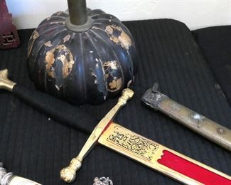 Spanish decorator sword, sword scabbard in front of a Japanese altar candle with gold applied design.