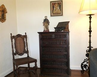 Carved Renaissance Revial side chair, Mexican carved chest of drawers, St Francis statue, carved wood book stand, Oil on canvas of Madonna and Child (age unknow, but not Spanish Colonial), and carved wrought iron floor lamp create a beautiful Corner.