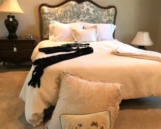 Queen bed with green toile upholstered headboard.