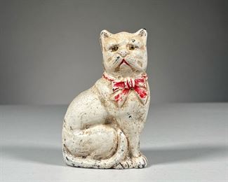 CAST IRON STILL BANK | With original paint, white cat still bank with red bow, held together by a screw in the back.