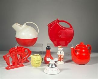 (9PC) MISC. KITCHENWARE | Vintage kitchen items and decor, including a red ceramic teapot, lemon juice pourer in the shape of a lemon, kitchen timer, red glass salt shaker, 2 red plastic napkin holders, and 2 red plastic pitchers. - h. 7 x dia. 6 in (Largest)