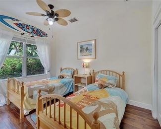 Gender Neutral Surfer bedroom - Twin beds convert to bunk beds with ladder and safety rail. There are 2 surfboards with racks, a surfboard rug, lamp, photo frame and switchplate cover.