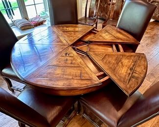 Custom Table made by Design Master. Table expands fro 54" Round to 70" Round plus total of 6 Custom Made Leather Chairs with Nail Head Trim. Looks like Brand New.