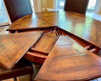 Custom Table made by Design Master. Table expands fro 54" Round to 70" Round plus total of 6 Custom Made Leather Chairs with Nail Head Trim. Looks like Brand New.