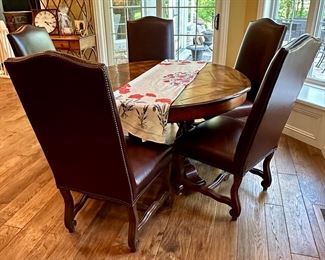 Custom Table made by Design Master. Table expands fro 54" Round to 70" Round plus total of 6 Custom Made Leather Chairs with Nail Head Trim. Looks like Brand New.