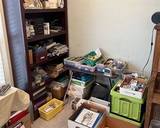 Bins of pens, pencils, envelopes, and other office supplies are almost overflowing on this table.