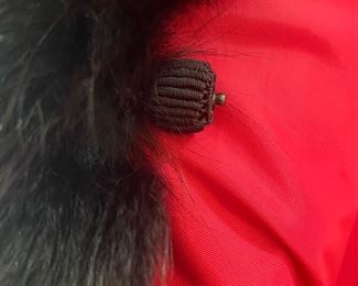toggle on the closure of the red leather vintage fur coat 