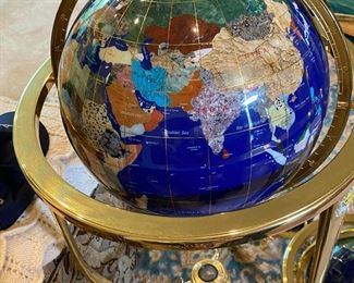 Hardstone floor model Glove of the Earth. The countries are represented by 18 different materials (e.g. Iran is turquoise, Germany is jasper, Mexico is black obsidian, etc.) Tripod-style base with a compass mounted in the center.