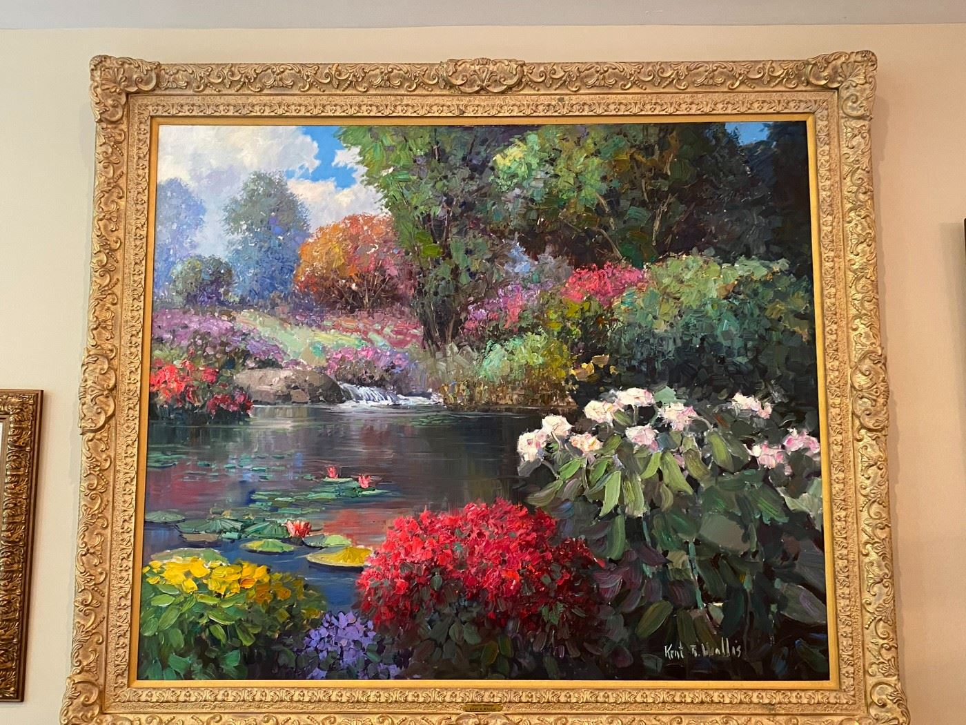 Oil on Canvas, "Garden Hideaway" by Kent R. Wallis. Commanding giltwood and composition frame with a foliate design. Scene of tranquil pond featuring water lilies, flowering bushes, and a small waterfall in the background. Provenance: purchased directly from the artist.