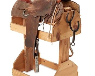1020
Circa 1970s; Eagar, AZ
A Western Saddle From 26 Bar Ranch
Tooled to cantle: Eikichi Suzuki; Impressed: 9012
The leather saddle with seat rise, billet strap, skirt, tooled seat, and leather and metal stirrups on a wood stand
Horn to cantle: 19.75"; swell width: 12"; gullet width: 18.5; overall on stand: 43" H x 22" W x 31" D
Estimate: $1,000 - $2,000