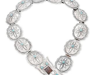 1025
Mid/late 20th century; Diné
A Navajo Silver Concho Belt
Appears unmarked
Comprised of a silver buckle with repoussé and stampwork motifs and set turquoise, together with eleven conchos with central set turquoise, all mounted to a leather belt strap, with one additional concho, 2 pieces
Buckle: 2" H x 3" W; each concho: 2" H x 2.5" W; strap: 31" L x 0.625" H
367.9 grams gross
Estimate: $700 - $900