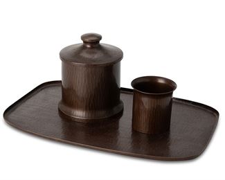 1043
Circa 1910-1915
A Group Of Roycroft Hammered Copper Table Items
All marked for Roycroft
Comprising a cup, a lidded humidor, and a tray, all with a patinated finish, 3 pieces
Larger: 0.25" H x 13.75" L x 9" W; smaller: 3" H x 2.75" Dia.
Estimate: $400 - $600