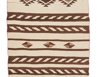 1057
Early 20th century; Diné
A Navajo Regional Blanket
Woven in cream, dark brown, and red wool with alternating striped bands and rows of serrated diamond motifs, with faded red wool ends and selvage stitching
37.5" H x 59" W
Estimate: $500 - $700