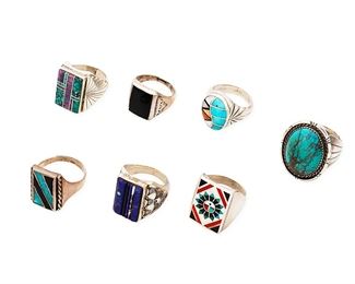 1064
Late 20th/21st century
A Collection Of Southwest Rings
Seven works:

Veronica Benally (b. 20th century, Diné)
A Navajo sterling silver and sculptural inlay ring
Stamped: V. Benally / Sterling
A rectangular multistone inlay ring including lapis and turquoise, with stamped silver flared band
Ring size: 10.5

Billy Slim (b. 20th century, Diné)
A Navajo sterling silver and turquoise ring
Stamped: B / Sterling
A large heavy cast sterling silver ring with set oval turquoise with heavy matrix
Ring size: 10.75

Fred and Lolita Natachu (b. 20th century, Zuni)
A Zuni sterling silver inlay ring
Stamped: FLN / Sterling
A sterling silver ring with Sunface inlay in turquoise, red and black
Ring size: 11

Four Southwest-style silver and stone set rings
One stamped: NH / [arrow and shield]
One ring with set onyx and three further rings with stone inlay in various colors and designs, 4 pieces
Largest: ring size: 11; smallest: ring size: 8.75

7 pieces total
120.9 grams gross
Estimate: $300 - $500