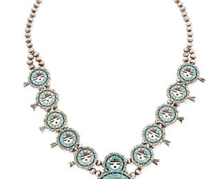 1106
Mid/late 20th century
A Zuni Silver And Inlay Squash Blossom Necklace
Appears unmarked
A Zuni squash blossom necklace with turquoise and multistone inlay Sunface motifs
27" L x 2.625" H
118.2 grams gross
Estimate: $400 - $600