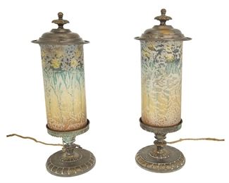1136
Circa 1910s-20s; Meriden, Connecticut
A Pair Of Handel Glass Torchiere Mantle Lamps
Each shade stamped: Handel 6989
Model no. 6989, each mantel lamp with a cylindrical glass shade decorated with reverse-painted daisies and acid-etched textured exterior finish on a molded patinated metal base with finial, electrified, 2 pieces
Each: 14.5" H x 5.25" Dia.
Estimate: $1,200 - $1,800