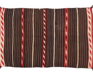 1165
Early/mid-20th century; Diné
A Navajo Moki-Style Blanket
Woven in red, cream, black and blue homespun wool with alternating black and blue stripes interspaced with hatched and diagonally striped bands
54" H x 80.5" W
Estimate: $3,000 - $5,000