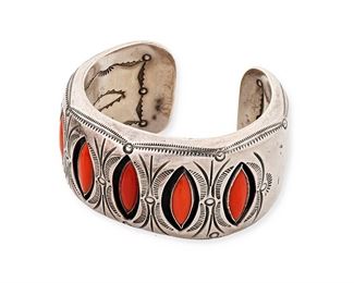 1173
Clarence Lee (B.1952, Diné)
A Navajo shadowbox coral and sterling silver cuff, late 20th century
Stamped: CO Lee
A heavy silver cuff bracelet with five shadowbox set coral stones with elaborate stampwork edging and interior accents
5.75" total inner C x 1.375" H, with a 0.75" gap
79.6 grams gross
Estimate: $500 - $700