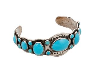1174
Mid-20th century; Diné
A Navajo Ingot Silver And Turquoise Cuff Bracelet
Stamped: 925
A Navajo 1920s-style silver ingot cuff with twenty-five graduated matched Hubbell bevel set turquoise stones
6.75" total inner C x 1" H, with a 1.5" gap
39.2 grams gross
Estimate: $400 - $600