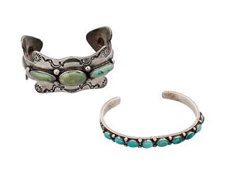 1175
Mid-20th century; Diné
Two Navajo Silver And Turquoise Cuff Bracelets
Each appears unmarked
Comprising a Navajo silver ingot cuff in an unusual shape with three set turquoise stones, and stampwork to edges with arrow shaped terminals (6.75" total inner C x 1.25" H, with a 1.25" gap), and a narrow silver ingot cuff with nine set matched turquoise stones and stampwork terminals (6.75" total inner C x 0.25" H, with a 1.125" gap), 2 pieces
79.4 grams gross
Estimate: $400 - $600