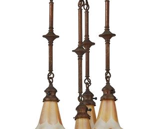 1188
20th century
A Tiffany-Style Light Fixture
The hammered copper hanging ceiling fixture with a wide canopy suspending four lights with foliate motif accents and pulled feather glass shades with iridescent gold interior, electrified
Overall: 28.5" H x 15.875" Dia.; each shade: 5" H x 4.25" Dia.
Estimate: $800 - $1,200